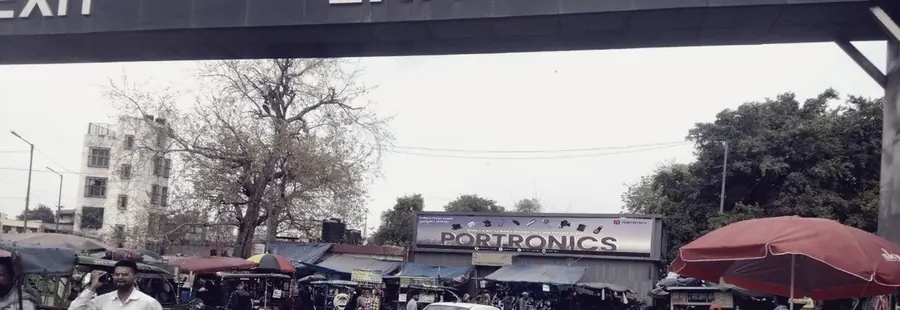 A crowded Delhi market street beneath an overpass