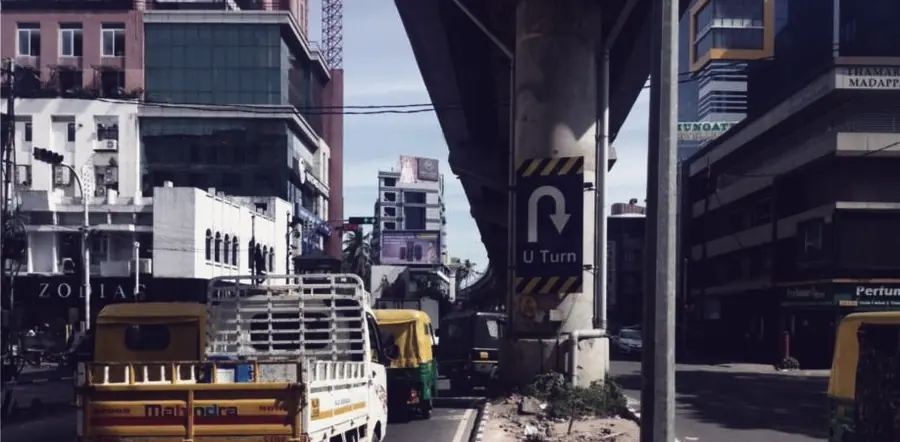 Traffic under a flyover on an arterial road in Kochi, hoardings on both approaches