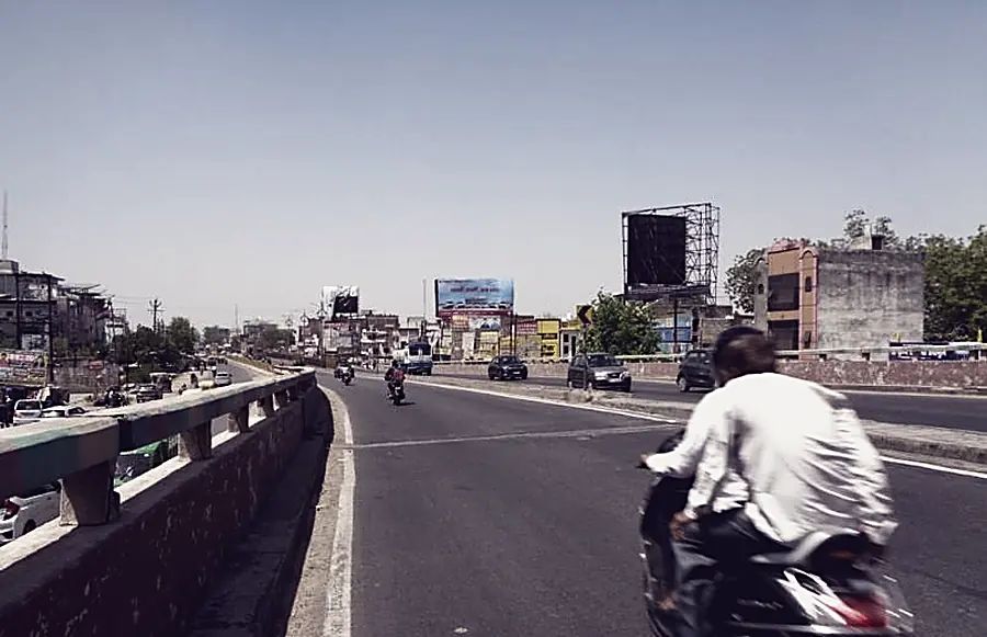 A commercial stretch in Agra with overhead signage and a gantry